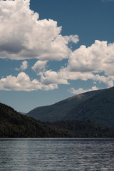 lake and mountains with clouds in the sky