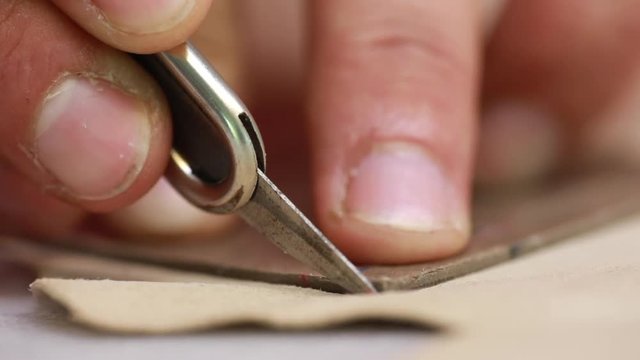Closeup of shoes making and cutting the pattern for the shoe parts before assembly with holes in the piece of leather in workshop for shoe manufacture traditional vintage shoemaker craftsman
