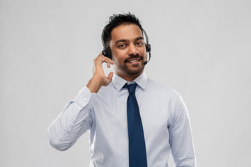 business, customer service and people concept - smiling indian businessman or helpline operator in...