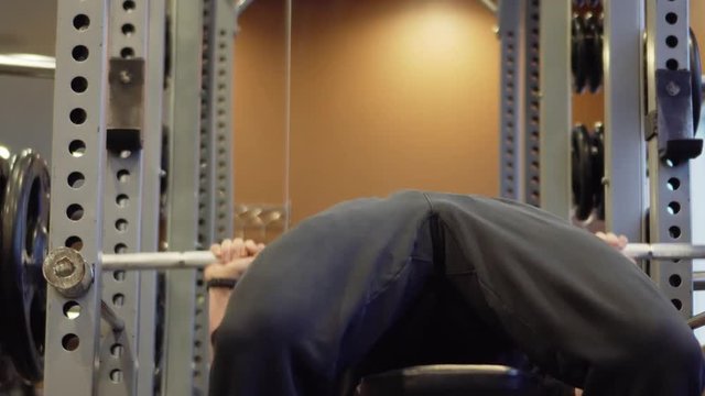 Person Lifting weights. Slow pan to the down. Shallow depth of field.
