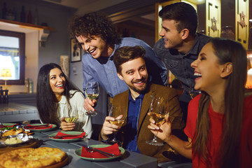 Happy friends talk in a restaurant in the evening. 