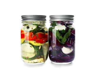 Fototapeta na wymiar Glass jars with fermented vegetables on white background