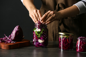 Woman preparing fresh cabbage for fermentation on table