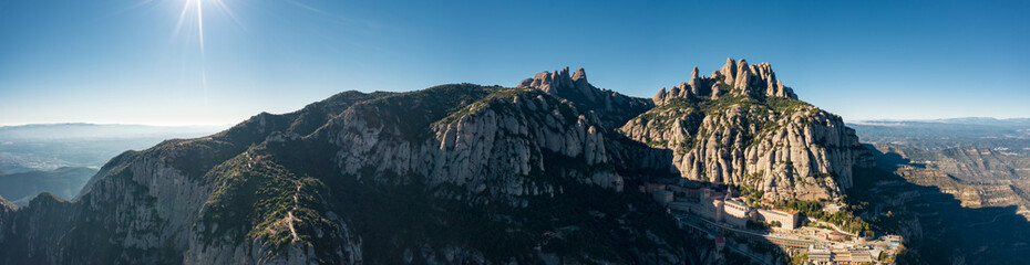 Aerial; wide panorama of famous abbey homonymous mountain range Montserrat; tourist attractions...