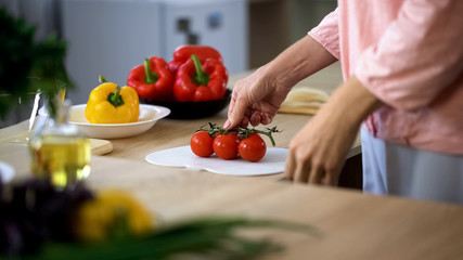 Housewife holding tomatoes preparing vegetarian family dinner, healthy nutrition