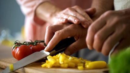 Loving wife holding husband hands, cooking family dinner together, nutrition
