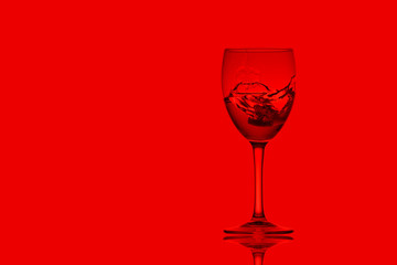glass with liquid   on red