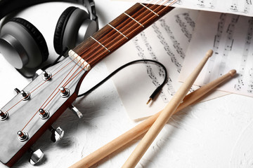 Composition with guitar, headphones and music sheets on white background
