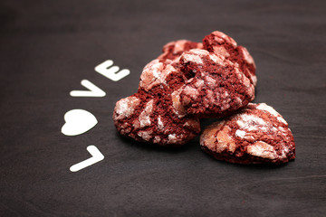 red chocolate cracked heart-shaped cookies on on a dark background. A gift for Valentine's Day, World Women's Day or Birthday