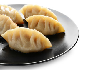 Plate with tasty Japanese gyoza on white background