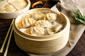 Bamboo steamer with tasty Japanese gyoza on table