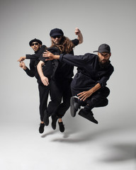 Hip hop dancers moving and jumping in photostudio