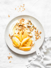 Greek yogurt with caramelized quince, granola, hazelnut on light background, top view. Delicious breakfast, dessert. Copy space