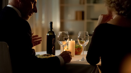 Aged elegant man and woman celebrating holiday in restaurant, romantic date