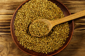 Fenugreek seeds in ceramic plate on wooden table