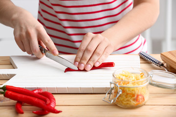 Woman preparing vegetables for fermentation at table