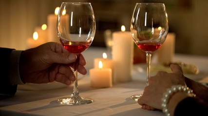 Gentleman with wine glass toasting, couple enjoying date, tasting elite alcohol