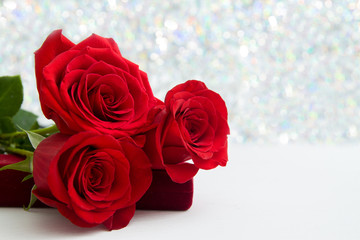 Three Red Roses and jewelery present box with boke Background. copy space - Valentines and 8 March Mother Women's Day concept.