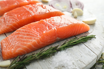 Raw salmon fillet on wooden board, closeup