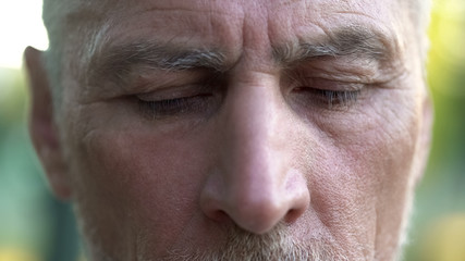 Upset senior male thinking about future, retirement and hopelessness, closeup