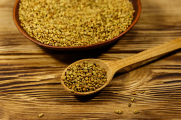 Fenugreek seeds in ceramic plate on wooden table