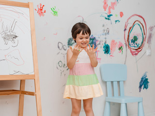 A little girl, 3 years old, painted an arched look with paint and a brush on the wall of her room....