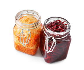Jars with tasty fermented vegetables on white background