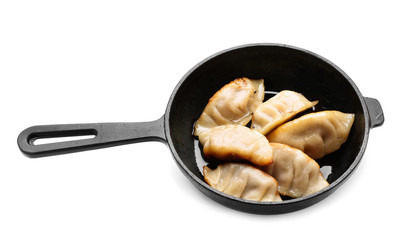 Frying pan with tasty Japanese gyoza on white background
