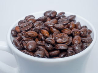 Coffee beans in coffee cup isolated on white