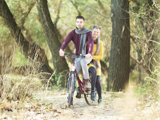 Fototapeta na wymiar Young beautiful couple on bicycle in nature