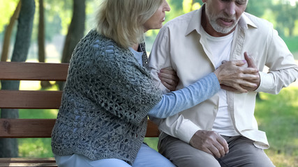 Mature male suffering heart pain during walk with wife, heart attack, healthcare