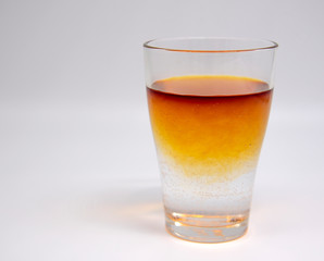 A glass of clean water, with orange brown spots. Painted with iodine