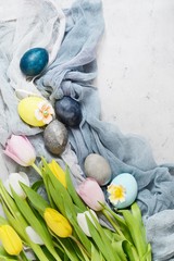 Bouquet of tulips with easter vintage eggs on a light gray background. Stylish Background with easter eggs, modern. Happy Easter card, spring flowers, copy space, space for text.