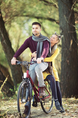 Fototapeta na wymiar Young couple riding a bicycle in springtime