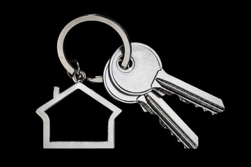 House keys with house shaped keychain, isolated on black background
