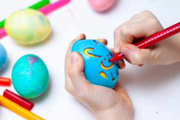 Little girl is preparing for Easter and painting eggs. Colorful markers. Rabbit template pattern.