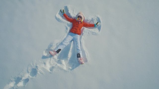 A woman throwing herself on the snow and making angels