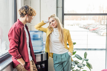 casual businessman and woman looking at each other and talking in loft office