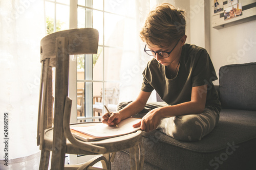 Close Up View Of A Young Boy Drawing On A White Sheet Kid