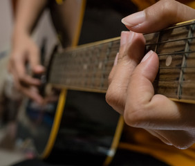 Woman's hands playing acoustic guitar.