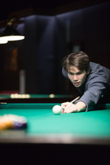 Entertainment concept. A young man playing billiard