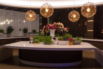 The table is beautifully decorated with flowers. Above the table, a round chandelier.
