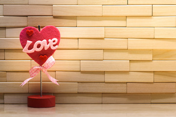 Happy valentine's day concept. Love word and red heart shape on wall made from wooden blocks under sunlight with copy space for wallpaper or background