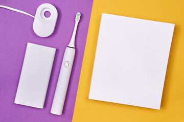 Smart electric toothbrush. Controlled by the application on the smartphone. Modern technology for health. Healthy teeth. Dentistry. White box Purple and yellow paper background