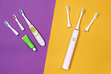 Adult and baby smart electric toothbrushes. Modern technology for health. Healthy teeth. Dentistry. Medical robot. Purple and yellow paper background