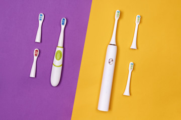 Adult and baby smart electric toothbrushes. Modern technology for health. Healthy teeth. Dentistry. Medical robot. Purple and yellow paper background