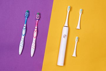 Manual and electric toothbrushes on pink coral background. Dental care
