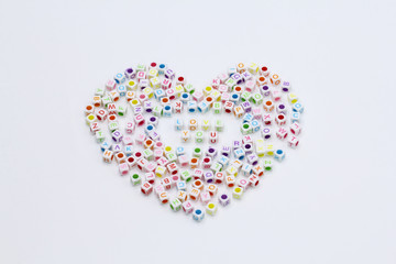 Colorful word love you made from alphabet cube beads surround with heart shape isolated on white background. Love and happy valentine's day concept