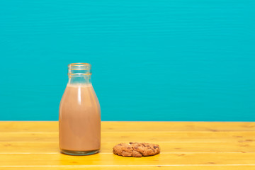 Chocolate milkshake in a milk bottle and a chocolate chip cookie