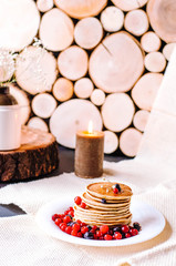 A stack of delicious pancakes with berries and honey.